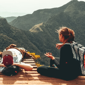 people sitting by edge of cliff